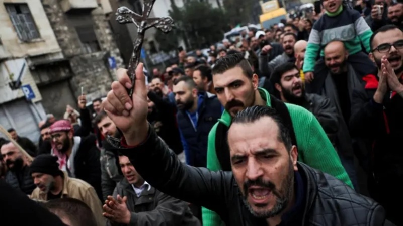 Protests erupt  as masked gunmen burns Christmas tree in Syria