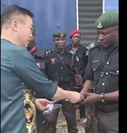 Chinese seen giving policemen money in viral video denies bribery allegation, apologises