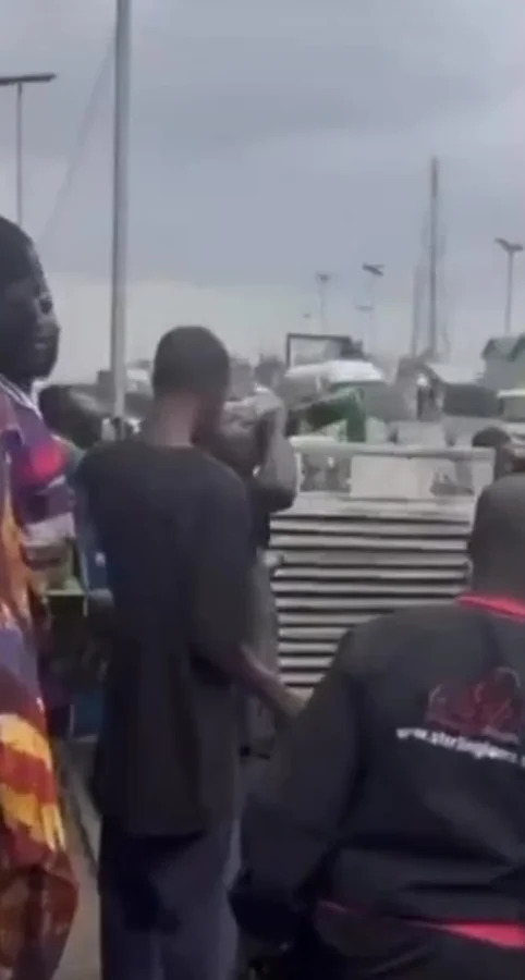 Bystanders drink beer from crashed truck in Lagos